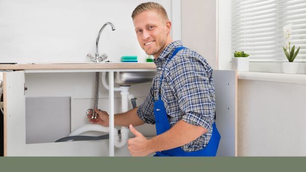 plumber working under sink