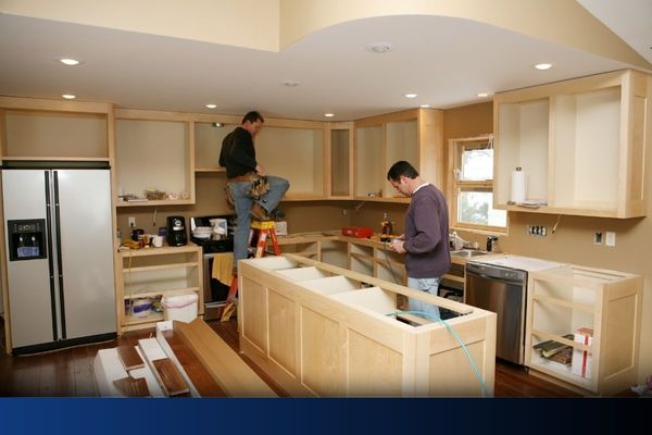 Two contractors renovating a home kitchen as part of a whole home rmeodel.