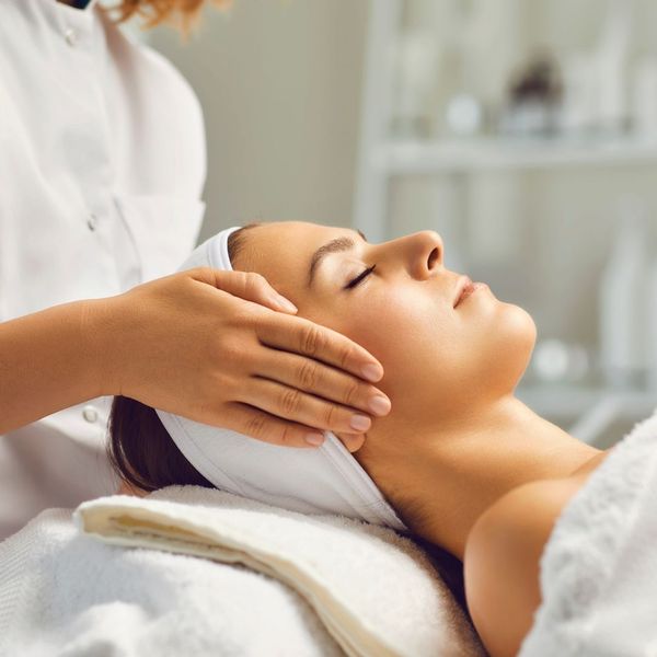 Woman having head massaged on a spa table