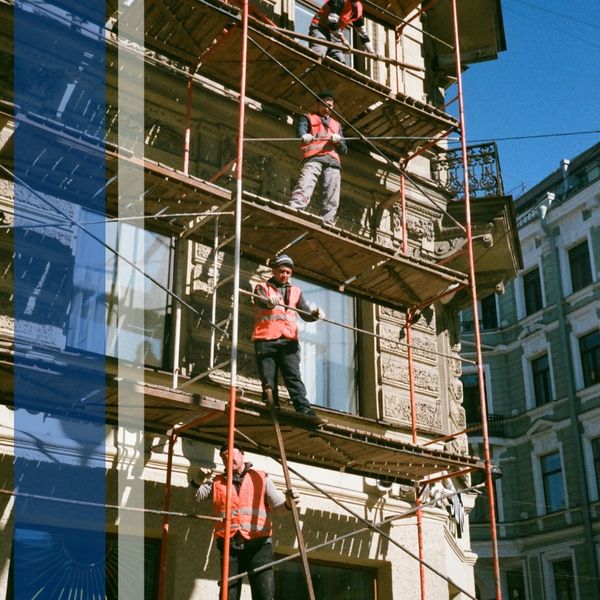 Construction workers on levels of scaffolding