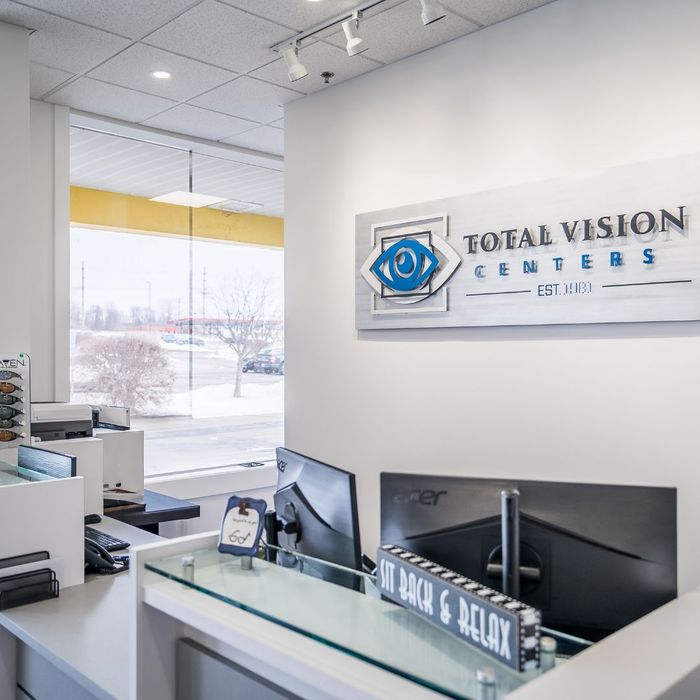 The reception desk at Total Vision Centers, featuring a sign with the company logo and "EST. 1981."