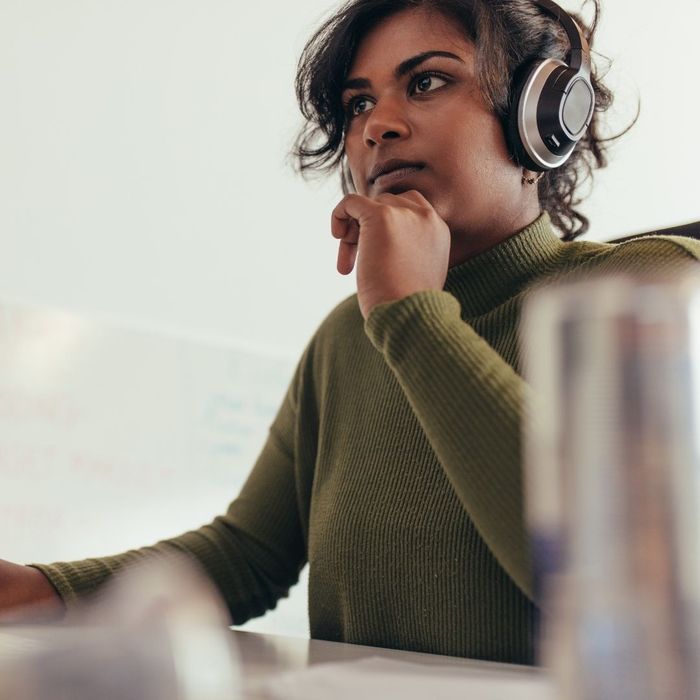 woman wearing headphones while working at computer woman wearing headphones while working at computer