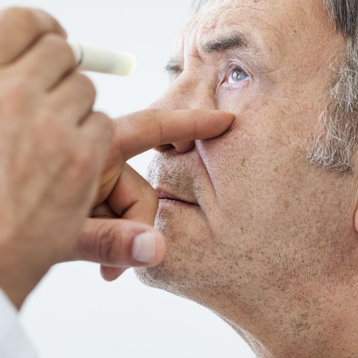 older man receiving eye exam older man receiving eye exam