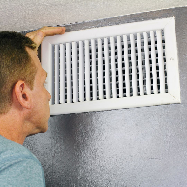 man inspecting air duct