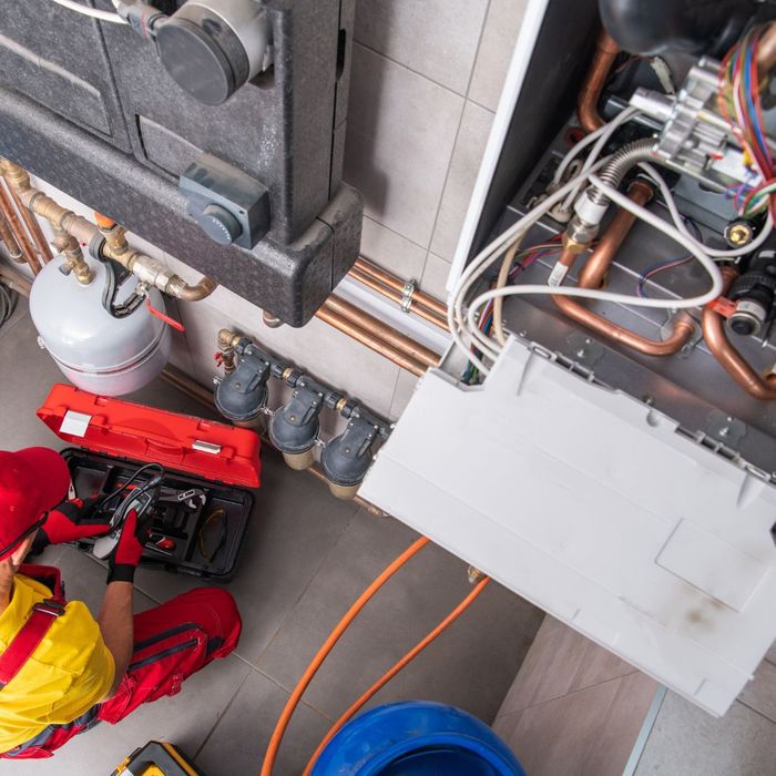 image of man performing maintenance on heating system