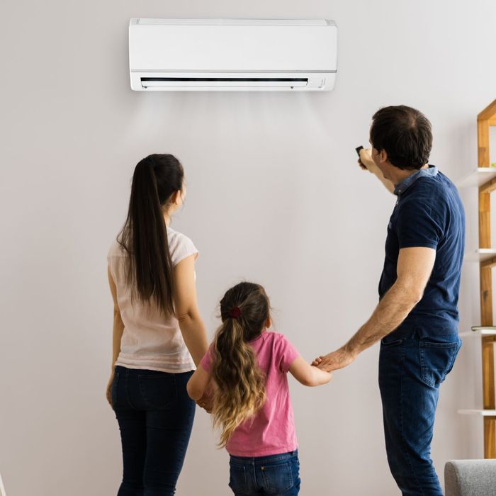 family standing around air conditioner