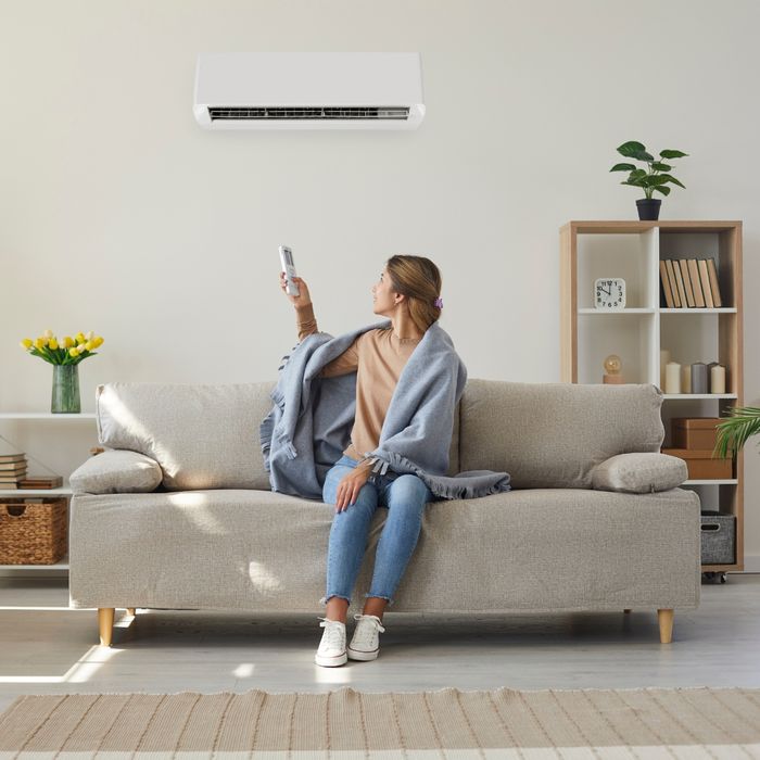 Comfortable woman adjusting HVAC with a remote