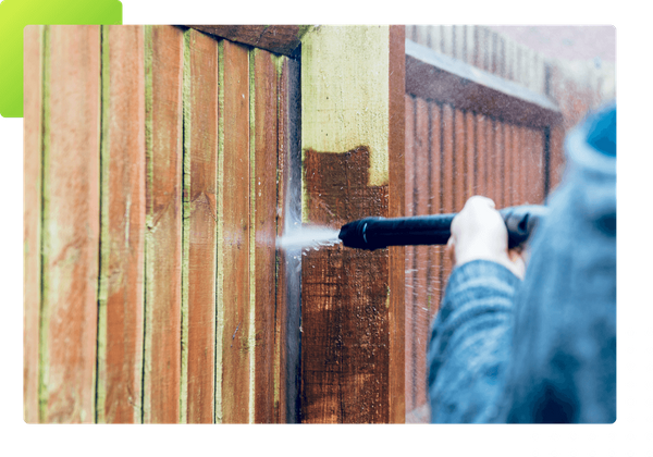 fence being cleaned with pressure washer