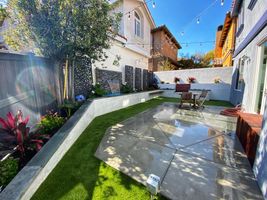 Backyard landscape with garden bed wall, new grass, and new concrete patio - Bonilla's Landscapes