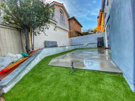 Backyard landscape with patio, grass, and stone wall - Bonilla's Landscapes