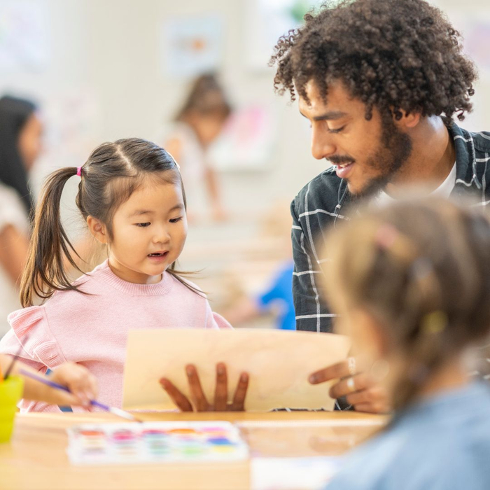 A staff member works with a toddler at daycare
