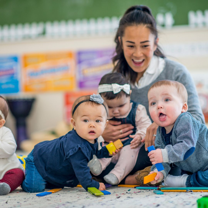 a teacher plays with her toddler students