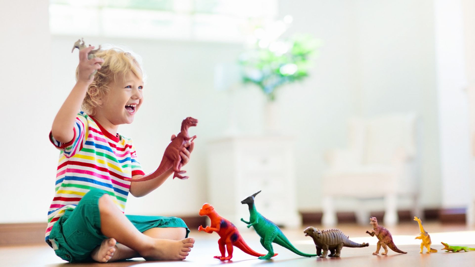 young child playing with dinosaurs