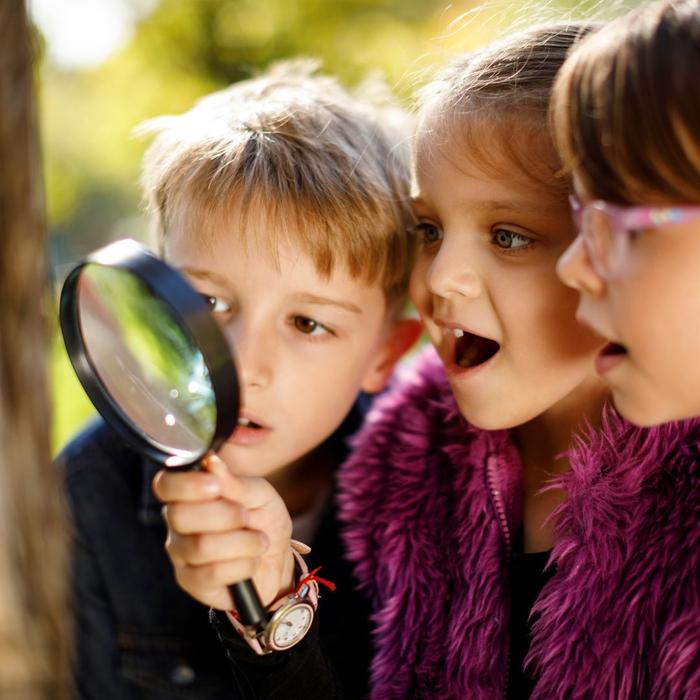 kids looking through magnifying glass