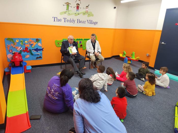 Person reading to a group of children at a child care center