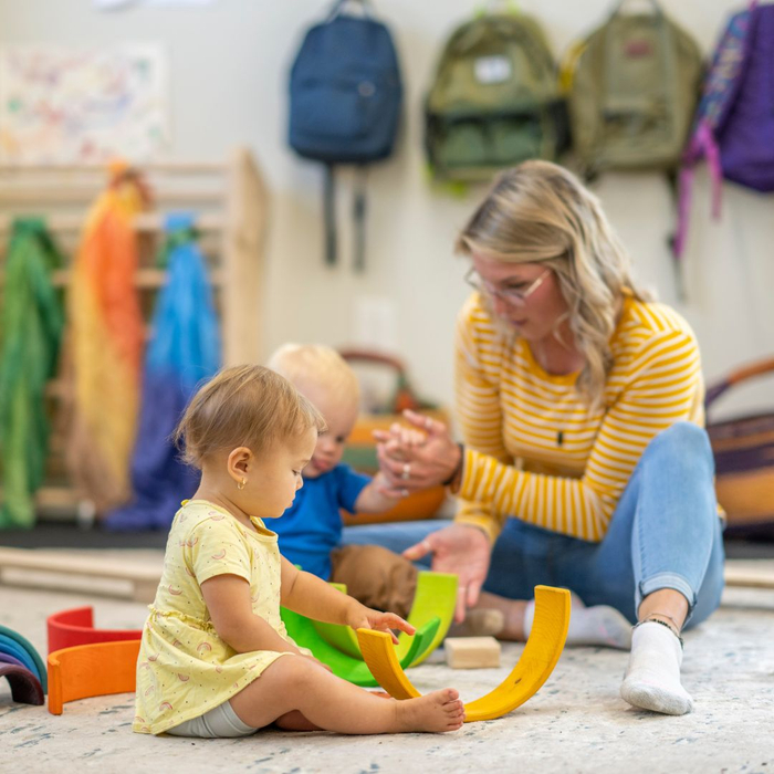 woman playing with infants at daycare