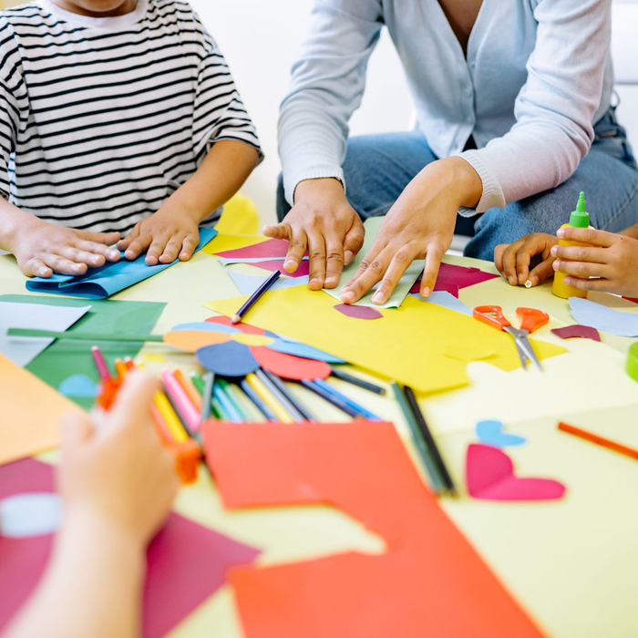 children working with an adult on paper crafts