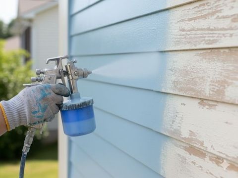 primed siding being painted blue