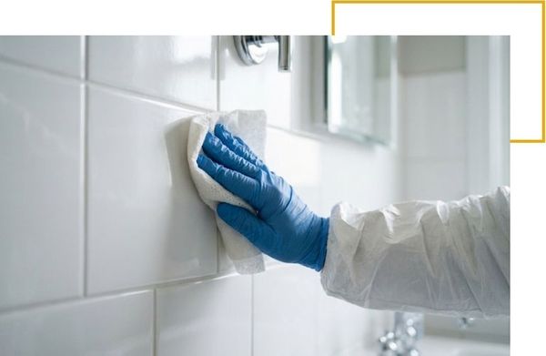 Technician sanitizing residential bathroom surfaces with medical-grade disinfectants.