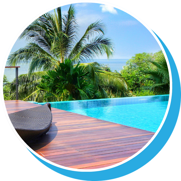 bright blue infinity pool, teak deck and lush palm trees, ocean in background