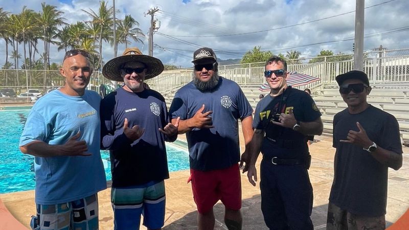 Five happy, diverse men, including the Da Pool Guy team, standing and giving shaka signs by a pool on a sunny day in Kauai. Five happy, diverse men, including the Da Pool Guy team, standing and giving shaka signs by a pool on a sunny day in Kauai.