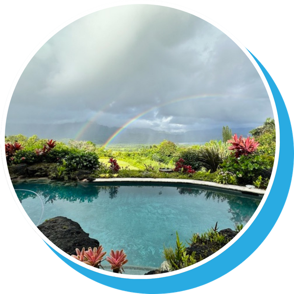 rainbow beyond large pool, lush foliage