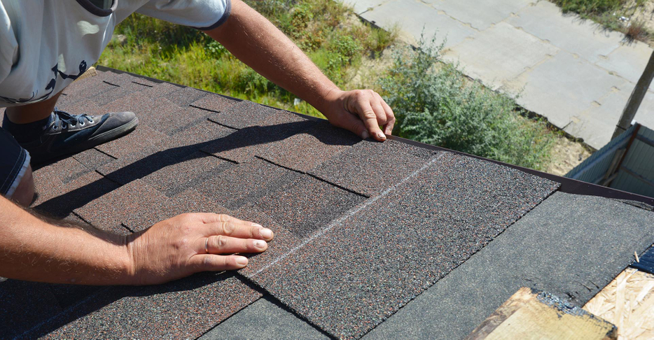 Roofer putting shingles on a roof
