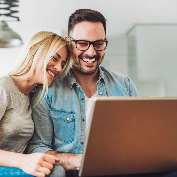 happy couple looking at laptop