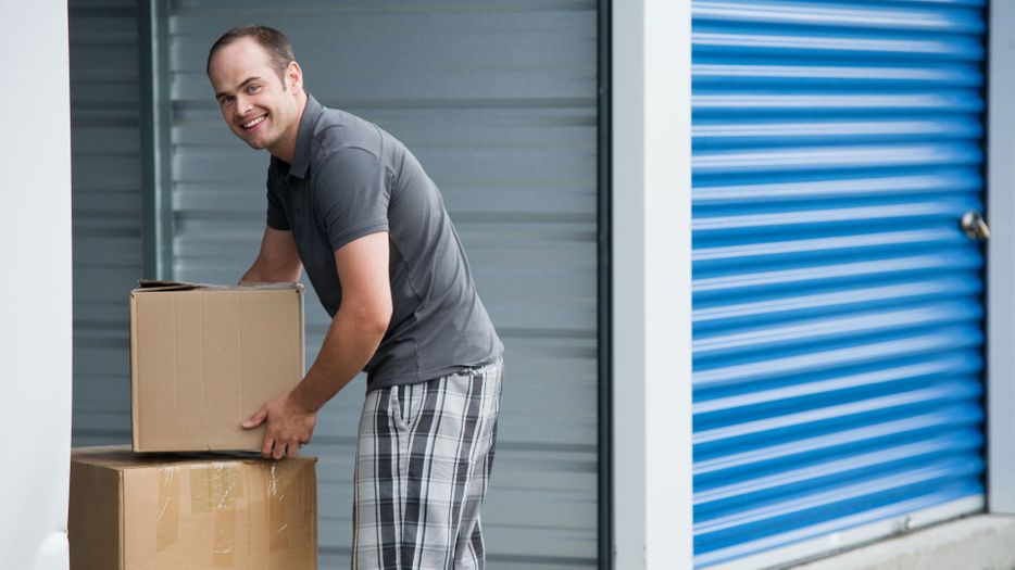man putting boxes in a storage unit