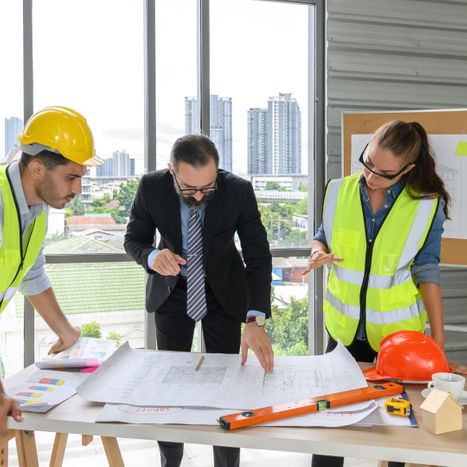 Business man looking over construction plans 