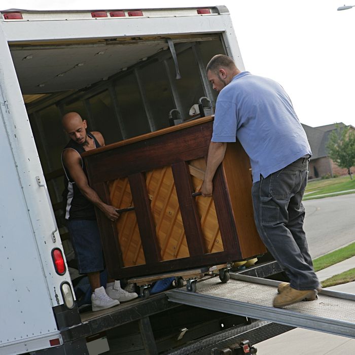Movers loading a piano onto the truck