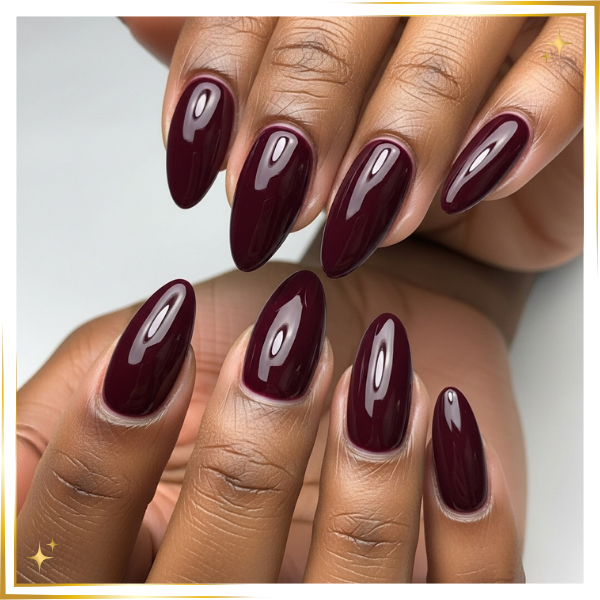 a woman's hand with a beautiful, durable hard gel manicure in a deep burgundy color