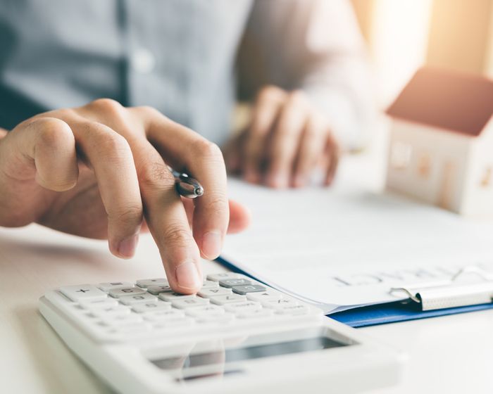 man adding up numbers with a calculator