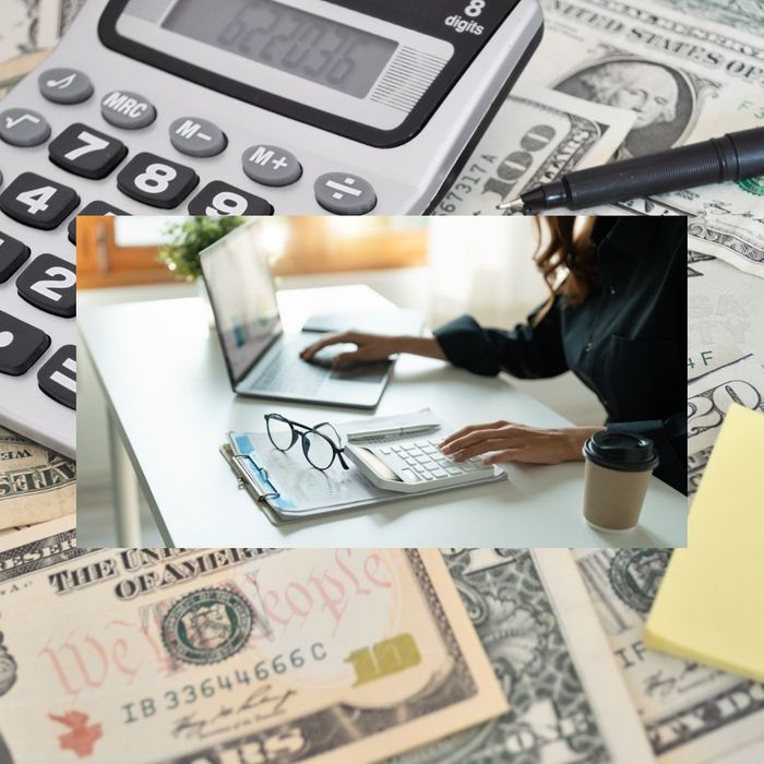 money and calculator with an overlaid image of a women working on her laptop