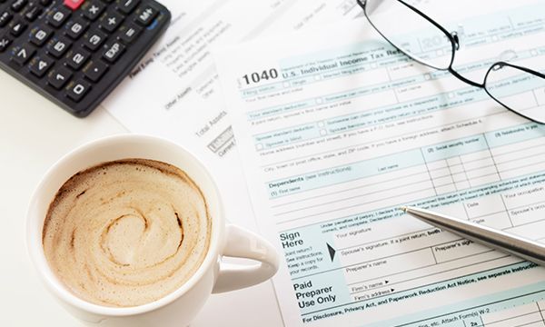 A coffee drink next to some tax documents