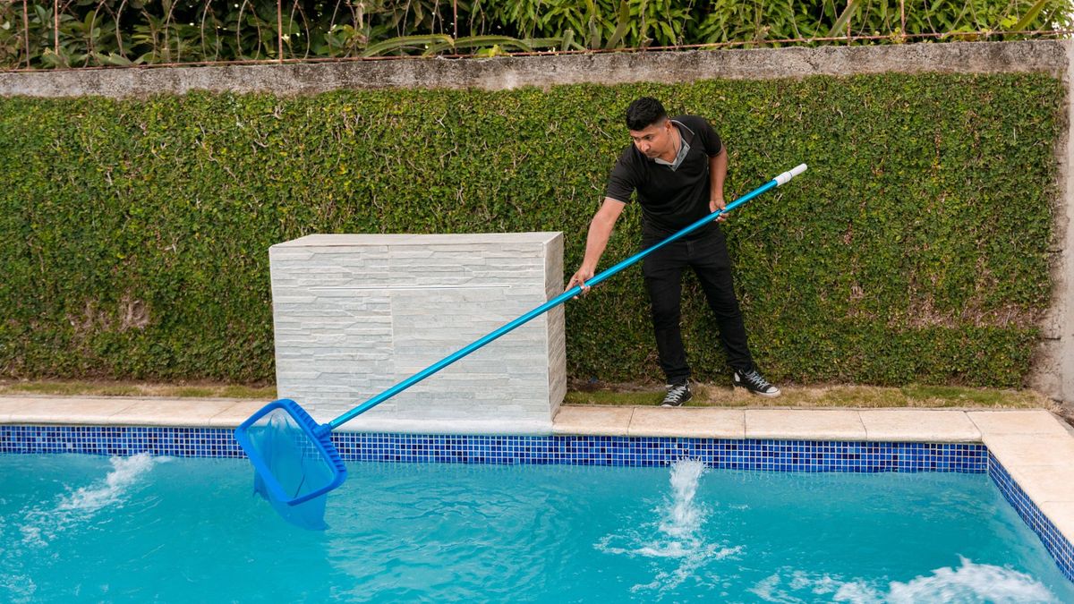 man cleaning pool