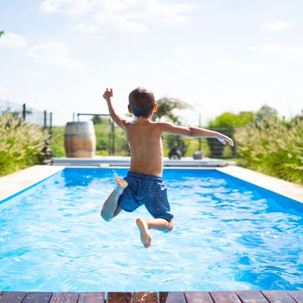 boy jumping in residential pool