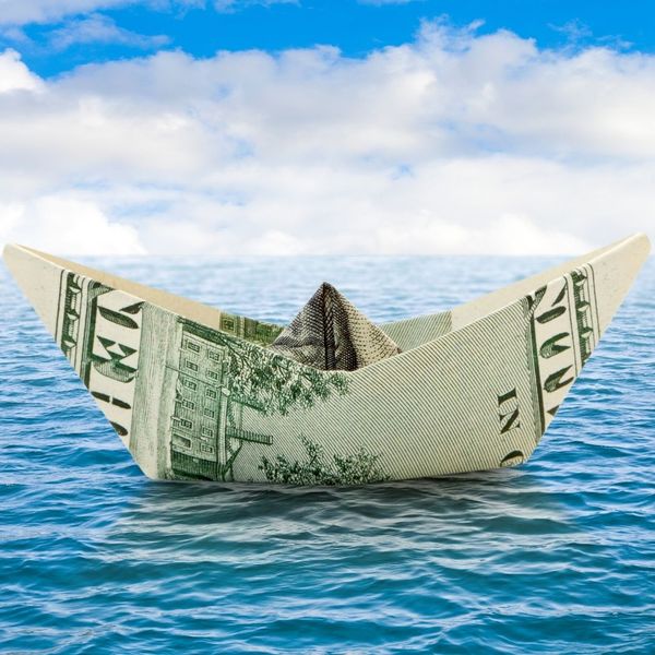 a paper boat made on money on the water