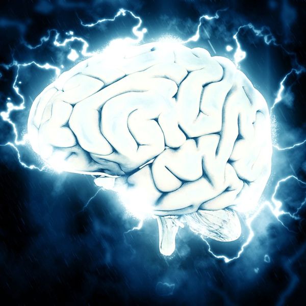 Glowing brain surrounded by electric energy on blue background