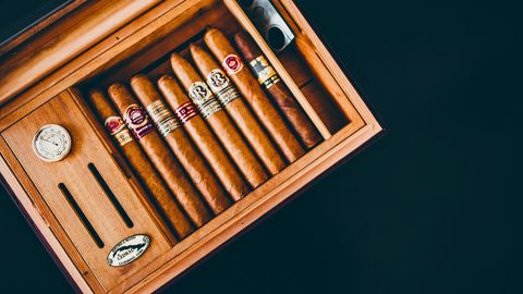 Wooden cigar box filled with various cigars