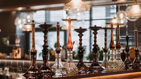 A row of glass hookahs on a bar counter