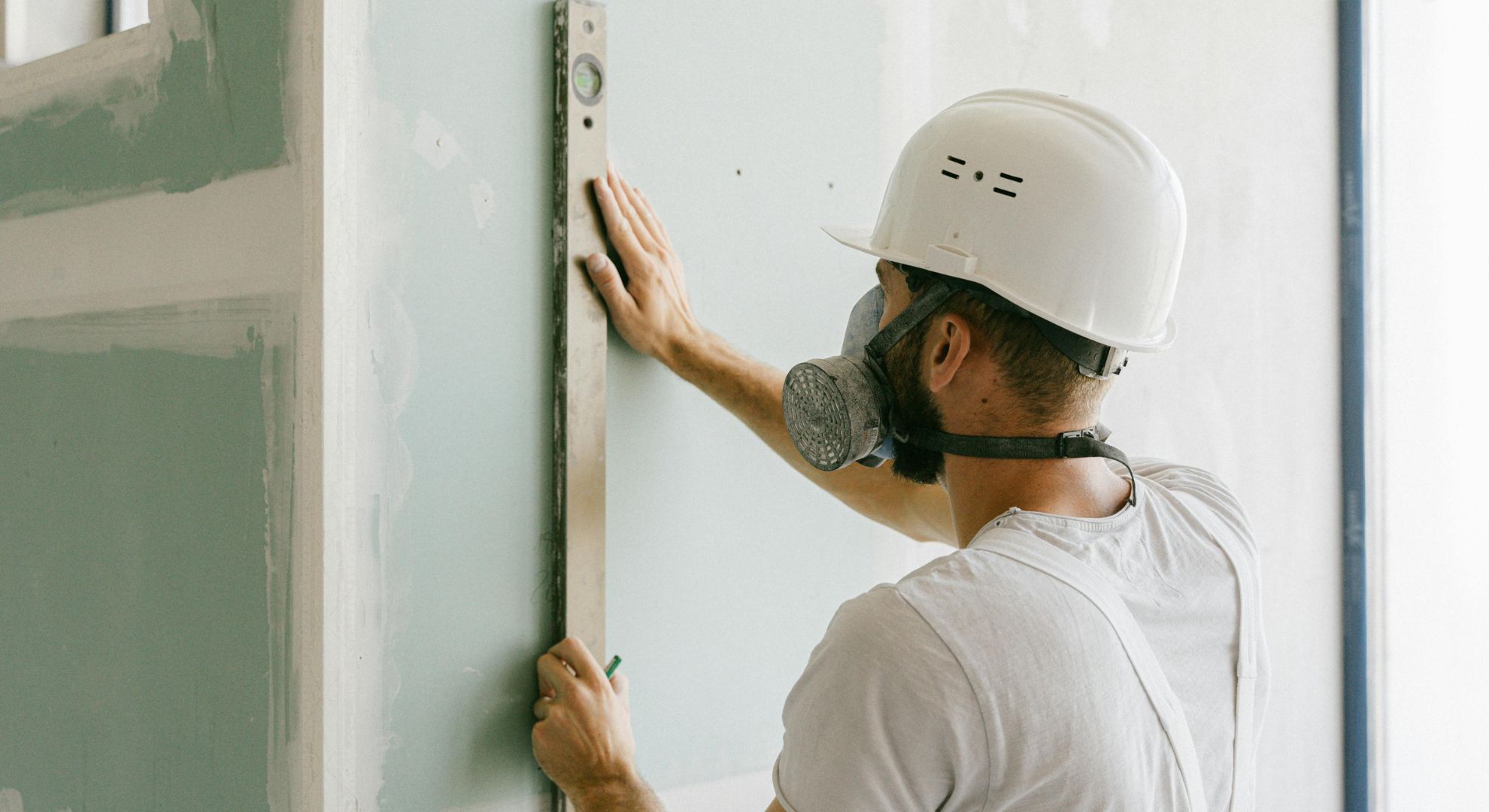 man holding a leveler to a wall man holding a leveler to a wall