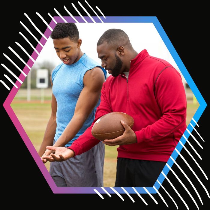 Football coach helping a player learn how to hold the ball