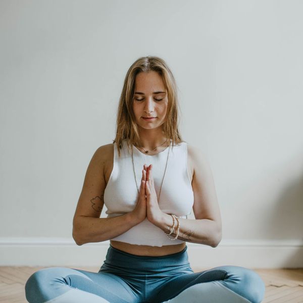 A woman practicing meditation inside 