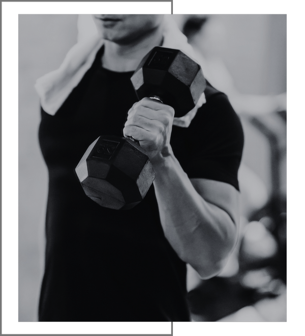 Man doing bicep curls with a towel draped over his neck