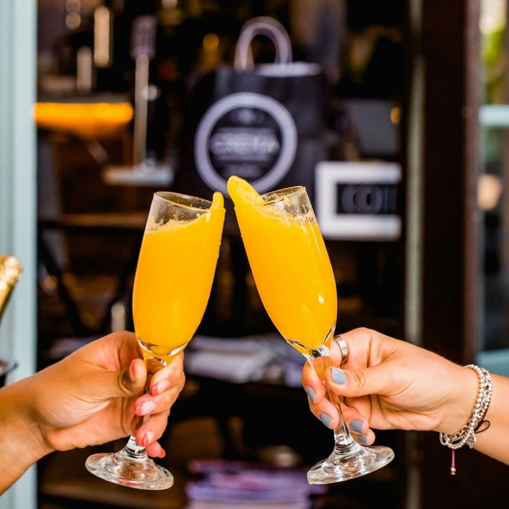 clinking together mimosa glasses