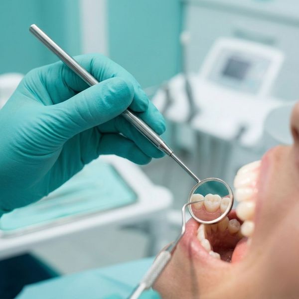 Close-up of a dental professional performing a routine check-up on a patient.
