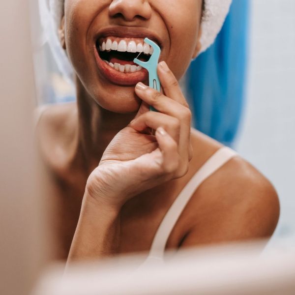smiling woman flossing teeth smiling woman flossing teeth