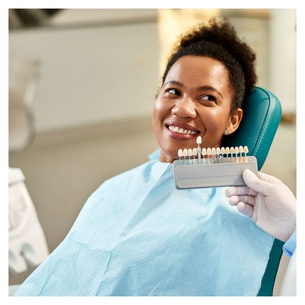 woman getting color matched for veneers at dentist