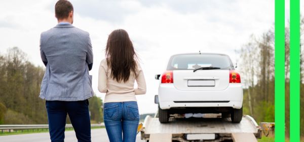 couple watching car being towed